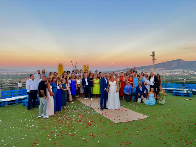 Foto de grupo de una boda al atardecer en el mirador