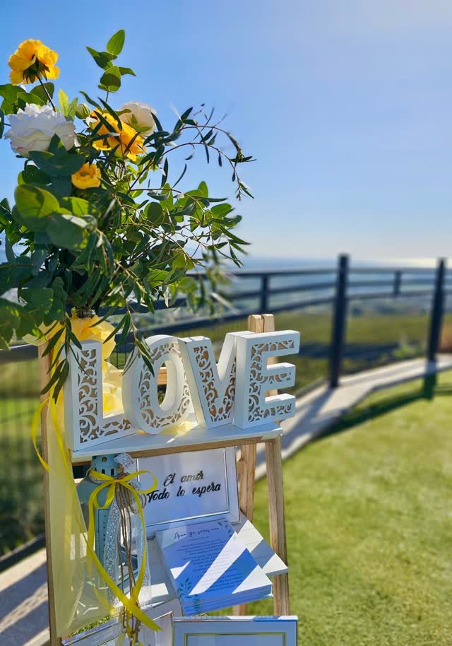 Decoración de boda con letras LOVE y flores amarillas